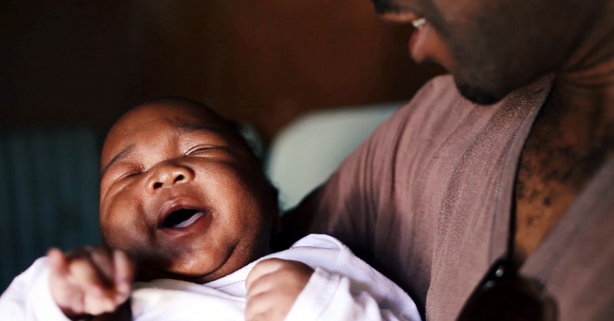 Andrew holds his newborn in a still from "MenCare Short: South Africa."