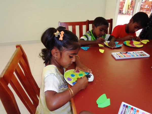 Children of MenCare participants work together on arts and crafts.